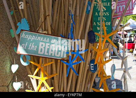 La felicità è una giornata in spiaggia Cartello in metallo e stelle marine decorazioni sul display in un negozio Foto Stock