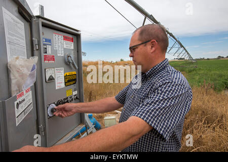 Shelley, Idaho - Idaho potato farmer Bryan Searle regola i controlli per un centro di irrigazione a perno sul sistema la sua fattoria. Foto Stock