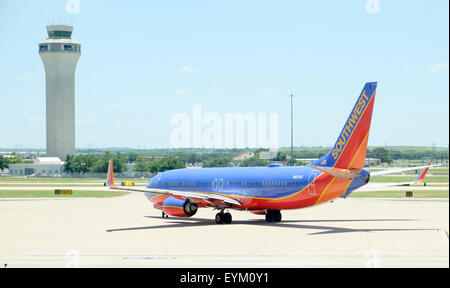Southwest Airlines Boeing 737 aviogetto rullaggio per il decollo con il controllo del traffico aereo torre in background a Austin in Texas Bergstrom Airport Foto Stock