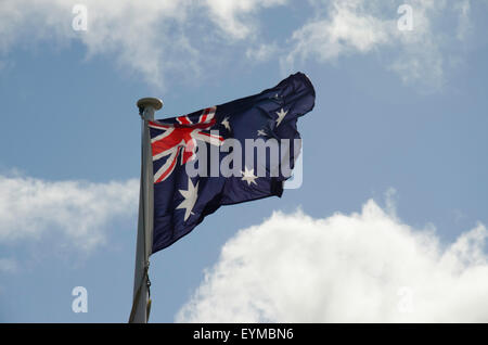 La bandiera nazionale australiana (bandiera blu) vola orgogliosamente sotto un bel cielo blu Foto Stock