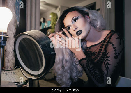 Maschio di drag queen mettendo su make up e vestirsi in preparazione per una performance Foto Stock