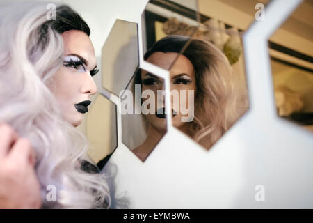 Maschio di drag queen in posa per pin-up stile ritratto glamour a casa.