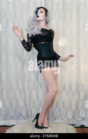 Maschio di drag queen in posa per pin-up stile ritratto glamour a casa.