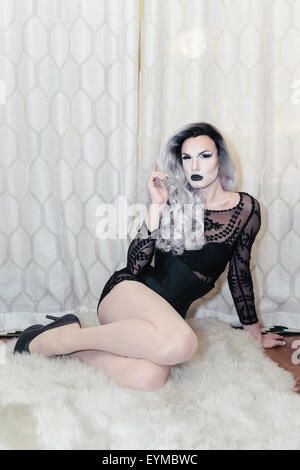 Maschio di drag queen in posa per pin-up stile ritratto glamour a casa.