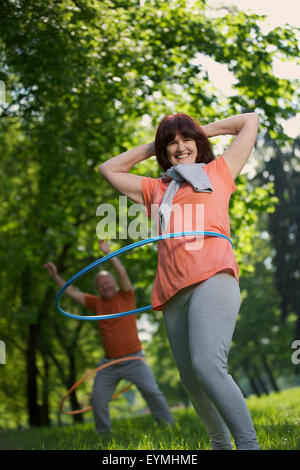 Coppia di anziani, sport, ginnastica, hula-hoop, natura Foto Stock