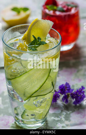 Rinfrescanti cocktail estivi - Gin Tonic con il cetriolo e lampone schiacciare in background Foto Stock