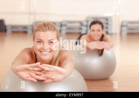 Donna facendo stretching sulla sfera di fitness Foto Stock