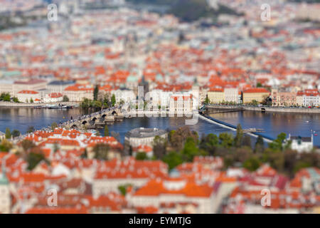 Vista aerea di Carlo ponte sul fiume Moldava e la città vecchia di Petrin Hill torre di osservazione con tilt shift effetto giocattolo deve Foto Stock