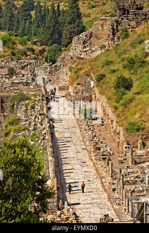 La strada principale di Efeso, Selcuk, Kusadasi, la Turchia con il grande anfiteatro in alto a destra. Foto Stock