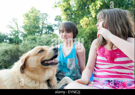 Un fratello e una sorella trascorrere del tempo di qualità con il cane di famiglia. Foto Stock