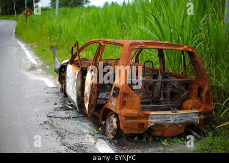 Incendiata auto sul lato della strada. Foto Stock