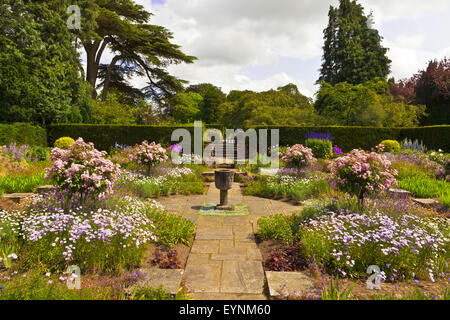 Un angolo tranquillo di un contrassegnato giardino inglese con vaso di pietra. Foto Stock