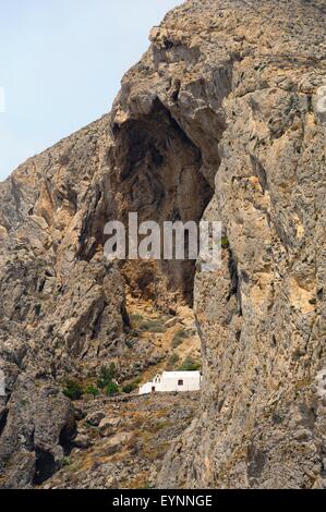 Una piccola chiesa di Katephani imbiancata costruita nella parete rocciosa di messa vouno, Perissa, Santorini, Grecia Foto Stock