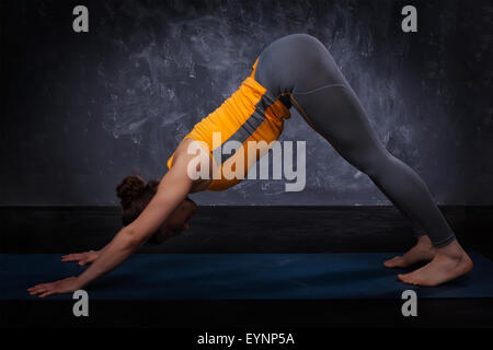 Bella sportiva montare yogi girl le pratiche yoga asana adhomukha sv Foto Stock