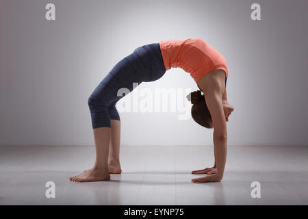 Bella sportiva montare yogi girl le pratiche yoga asana chakrasana Foto Stock