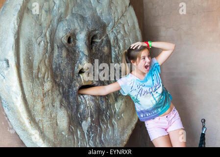 Bocca della Verita Roma, giovane turista, si pone di fronte alla famosa bocca della Verita nello storico quartiere Aventino, Roma Italia Foto Stock