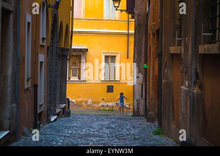 Roma quartiere ebraico, un bambino corre in una stretta strada di Sant'Angelo del distretto di Roma, Italia. Foto Stock