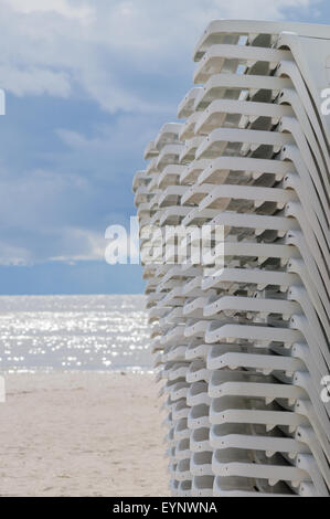 Impilate i lettini prendisole sulla spiaggia prima di tempesta Foto Stock