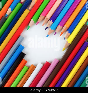 Set di bright matite colorate disteso in una forma di cuore. Foto Stock