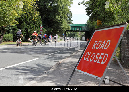 Esher, Surrey, Inghilterra, Regno Unito. Il 2 agosto 2015. Molte strade nel Surrey e Londra sono chiusi per i ciclisti dilettanti che partecipano alla Corsa prudenzialiLondon-Surrey 100. La 100 Miglia di sfida è lungo lo stesso percorso come i professionisti, con l'incentivo aggiunto per la raccolta di fondi per una buona causa. Un gruppo di ciclisti passare lungo il Portsmouth Road in direzione di Kingston sul homeward gamba della corsa. Credito: Julia Gavin UK/Alamy Live News Foto Stock