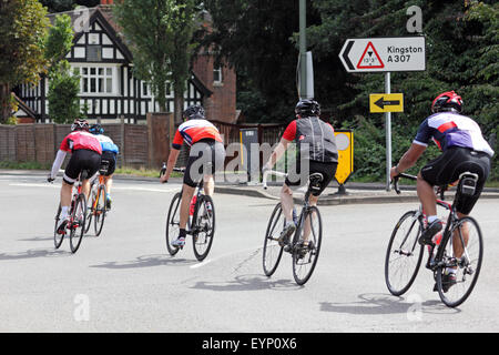 Esher, Surrey, Inghilterra, Regno Unito. Il 2 agosto 2015. I ciclisti dilettanti che partecipano alla Corsa prudenzialiLondon-Surrey 100. La 100 Miglia di sfida è lungo lo stesso percorso come i professionisti, con l'incentivo aggiunto per la raccolta di fondi per una buona causa. Un gruppo di ciclisti passare il un cartello stradale a isole Scilly rotonda lungo il Portsmouth Road in direzione di Kingston sul homeward gamba della corsa. Foto Stock