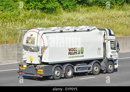 Retro e vista laterale legno Pellets bulk soffiato carburante consegna autocisterna hgv camion guida lungo l'autostrada inglese M25 strada Essex Inghilterra UK Foto Stock