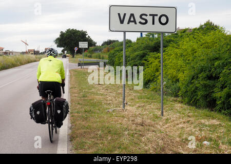 Una touring ciclista passato di equitazione un cartello stradale e inserendo i limiti della città di Vasto Foto Stock