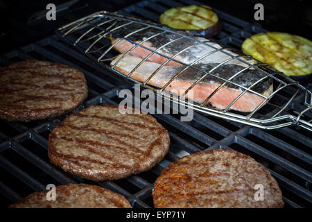 Hamburger fette, bistecca di salmone e melanzane alla griglia, rack, soft focus Foto Stock