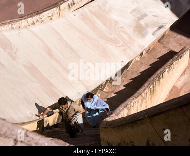 Indian giovane climbing scalinata adiacente alla gigantesca meridiana a Jantar Mantar osservatorio astronomico di Jaipur India Foto Stock