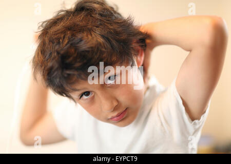 Tempo letto - boy spazzole i suoi capelli - molto leggera profondità di campo Foto Stock