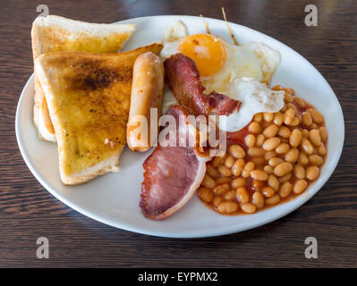 Café pasto una piccola prima colazione inglese con bacon uova fritte salsiccia fagioli al forno e un fritto prugna pomodoro servita nello Yorkshire Foto Stock