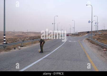 Un soldato israeliano si trova in posizione di guardia in un checkpoint mobile in Cisgiordania Israele Foto Stock