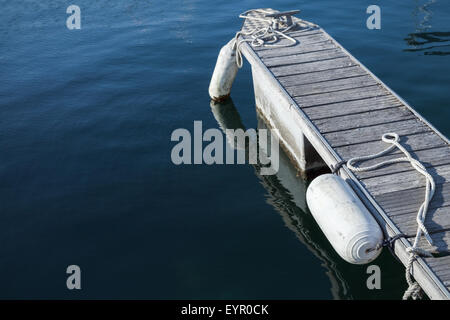 Piccolo molo galleggiante per yacht di attracco con parafanghi bianco Foto Stock