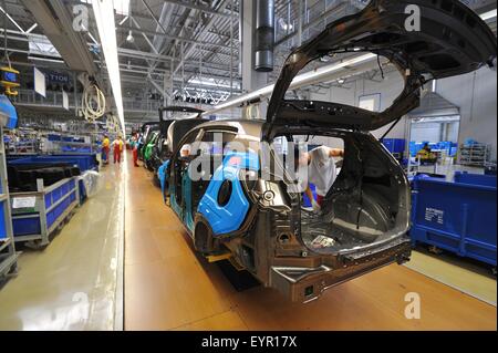 All'interno di una moderna fabbrica di automobili e veicoli e parti si muovono attraverso il processo di produzione, corpo dipinto gusci sul trasportatore in movimento Foto Stock