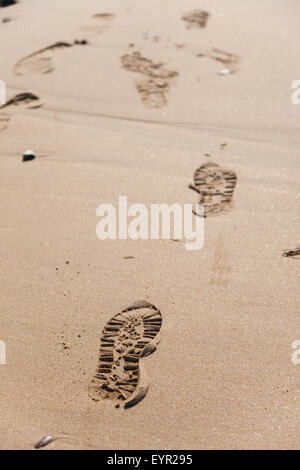 Piedi stampe in sabbia su una spiaggia. Foto Stock