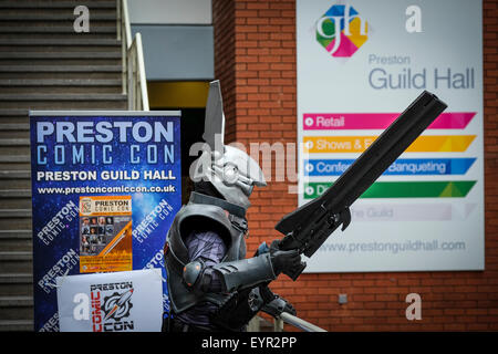 Preston, Regno Unito. Fumetto con evento a Preston Guild Hall con uomo in costume futuristico e pistola di grandi dimensioni accanto al caso banner. Foto Stock