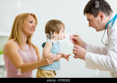 Medico dando un cucchiaio di sciroppo al bambino Foto Stock