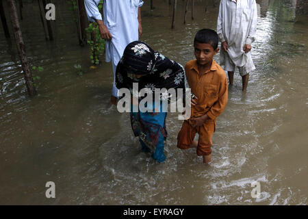 A Peshawar, Pakistan. Il 3° agosto 2015. Pakistani wade attraverso inondazione nella periferia della città di Peshawar, a nord-ovest del Pakistan, il 3 agosto, 2015. Credito: Umar Qayyum/Xinhua/Alamy Live News Foto Stock