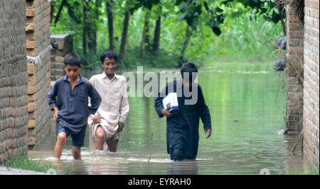 A Peshawar, Pakistan. Il 3° agosto 2015. Ragazzi pakistani wade attraverso inondazione nella periferia della città di Peshawar, a nord-ovest del Pakistan, il 3 agosto, 2015. Credito: Umar Qayyum/Xinhua/Alamy Live News Foto Stock