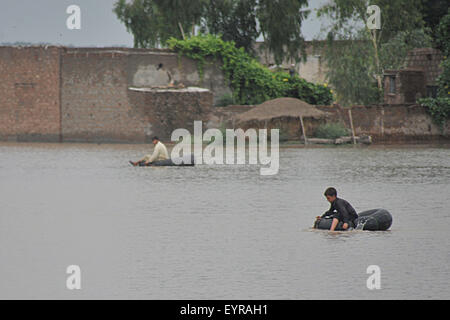A Peshawar, Pakistan. Il 3° agosto 2015. Proiettore pakistano le persone colpite da attraversare alluvione con zattere alla periferia di Peshawar, a nord-ovest del Pakistan, il 3 agosto, 2015. Credito: Umar Qayyum/Xinhua/Alamy Live News Foto Stock