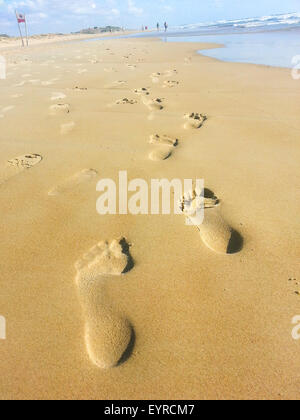 Orme umane che portano lontano nella sabbia Foto Stock