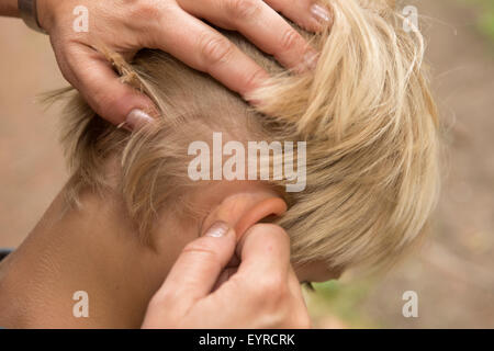 Il trattamento per aspirare i pidocchi - bambino piccolo ragazzo biondo capelli con i pidocchi Foto Stock