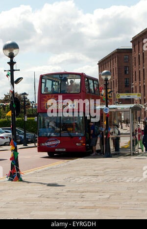 Immagine editoriale scattata a Liverpool del tour in autobus turistico Red con passeggeri che salpano dalla fermata dell'autobus Albert Dock. Foto Stock