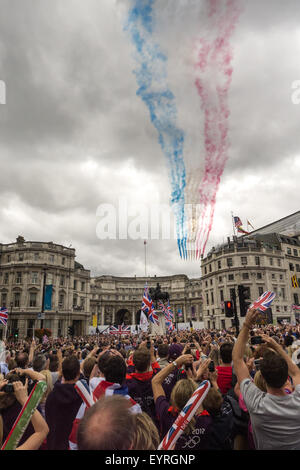 Trafagar Square, Londra, Engand. Le frecce rosse volare oltre lo streaming di rosso bianco e blu sopra la folla con Union Jack Flag. Foto Stock