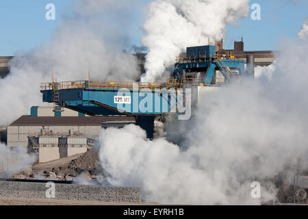 Gru a portale con molte nubi di vapore in un olandese fabbrica di acciaio Foto Stock