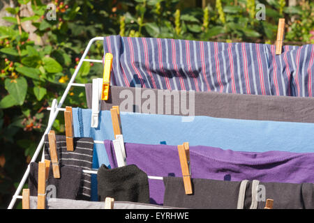 Telaio di essiccazione con i vestiti in giardino Foto Stock