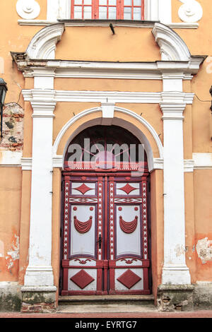 Close up vista frontale di antica e storica porta di legno di giallo e arancione edificio. Foto Stock