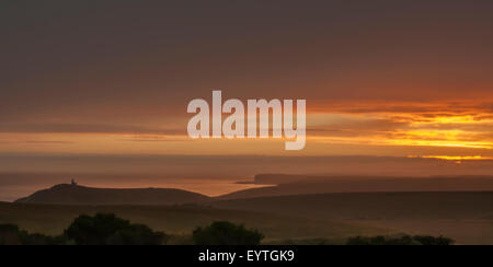 Eastbourne, East Sussex, Regno Unito.3 agosto 2015.Glorious pastello colori come il sole tramonta dietro le nuvole e Sea Mist rotola nella creazione di una scena eterea su Birling Gap e East Dean. Foto Stock