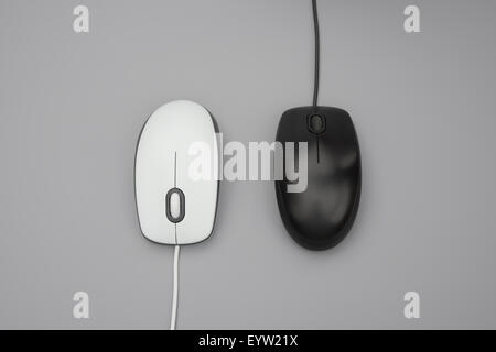 Il bianco e il nero mouse con cavi su sfondo grigio Foto Stock