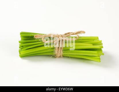 Mazzetto di erba cipollina fresca su sfondo bianco Foto Stock